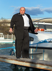 Image showing Fat man in tuxedo on deck boat