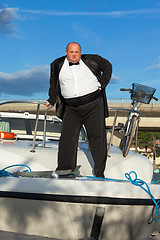 Image showing Fat man in tuxedo on deck boat