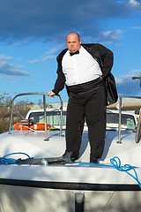 Image showing Fat man in tuxedo on deck boat