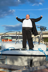 Image showing Fat man in tuxedo on deck boat