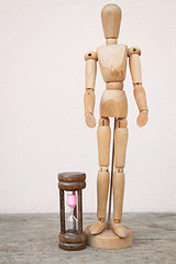 Image showing Wood mannequin and hourglass to represent spending time