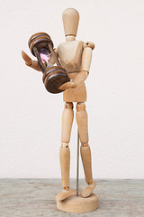 Image showing Wood mannequin and hourglass to represent time caring 