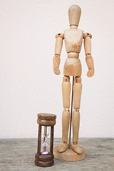 Image showing Wood mannequin and hourglass to represent time over 