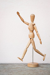 Image showing Wooden figure pose as happy jumping forward