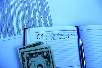 Image showing writing down in notebook about a debt