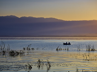 Image showing The first rays of the sun and fishermen