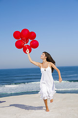 Image showing Beautiful girl running with red ballons