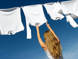 Image showing Longhaired girl, blue sky and white laundry