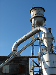 Image showing Factory building with water tower and metal pipes