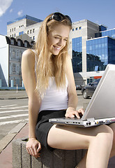 Image showing girl with laptop in a hi-tech urban surrounding