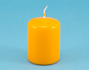 Image showing yellow thick wax candle wick blue background 
