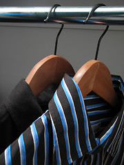 Image showing Two stylish shirts on wooden hangers