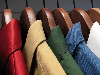 Image showing Colorful shirts on wooden hangers