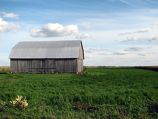 Image showing Old wooden barn in the green field