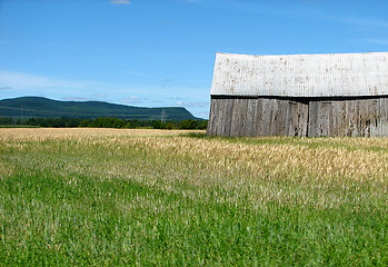 Image showing Mountains and old wooden barn in the field