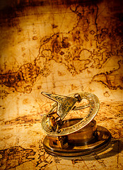 Image showing Vintage compass lies on an ancient world map.