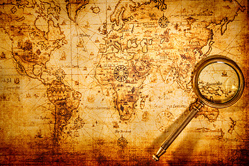 Image showing Vintage magnifying glass lies on an ancient world map