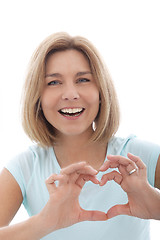 Image showing Laughing woman making a heart gesture