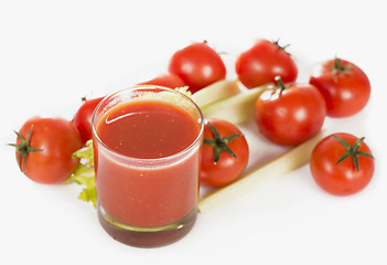 Image showing Glass of tomato juice and tomatoes on a white background