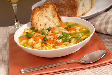 Image showing Bowl of chicken noodle soup with rustic bread and a glass of win