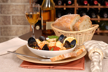 Image showing Bowl of seafood soup with wine and rustic bread