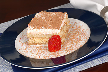 Image showing A piece of tiramisu dusted with cocoa on a blue plate