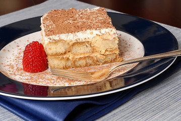 Image showing Side view of a piece of tiramisu dusted with cocoa with a fork o