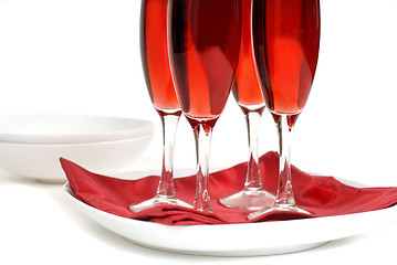 Image showing Four glasses of rose champagne on a red napkin isolated on white