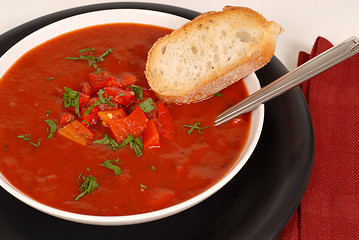 Image showing Overhead view of a bowl of tomato, red pepper and basil soup wit