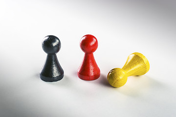 Image showing Standing black and red and lying yellow Ludo figure