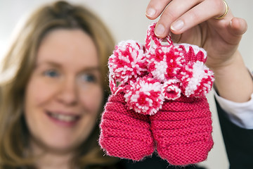 Image showing Blond woman with baby shoes