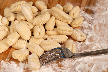 Image showing Freshly made potato gnocchi on a floured cutting board