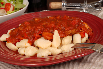 Image showing Close up of potato gnocchi with marinara sauce with a salad