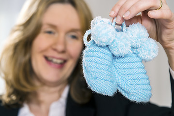 Image showing Blond woman with blue baby shoes