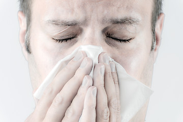 Image showing Ill man with tissue is sneezing