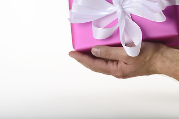 Image showing gift in purple paper holding in hand