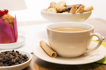 Image showing Cup of coffee with beans and muffin