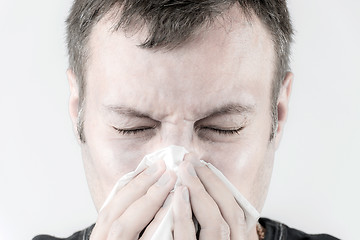 Image showing Ill man with tissue is sneezing