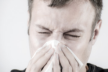 Image showing Man with tissue is sneezing