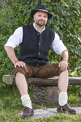 Image showing Seated man in traditional Bavarian costumes