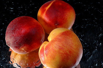 Image showing 3 peaches on a reflective surface