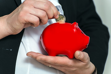 Image showing Close up pregnant business womans hands with piggy bank