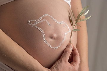 Image showing Pregnant woman with cream pigeon on her baby bump