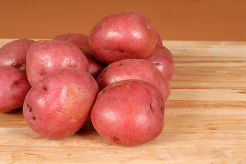 Image showing Several red potatoes piled on a cutting board