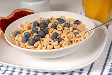 Image showing Bowls of oat cereal with blueberries and spoon, toast with raspb