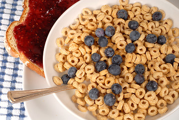 Image showing Overhead view of oat cereal with blueberries and spoon, toast wi