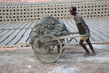 Image showing Laborers are carrying soil from the river and keeping them in the brick field area