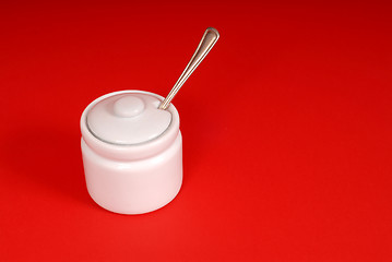 Image showing White sugar bowl on a red background