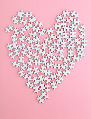 Image showing puzzle made heart shape on pink background