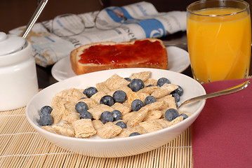 Image showing Wheat cereal with blueberries, toast, orange juice and newspaper